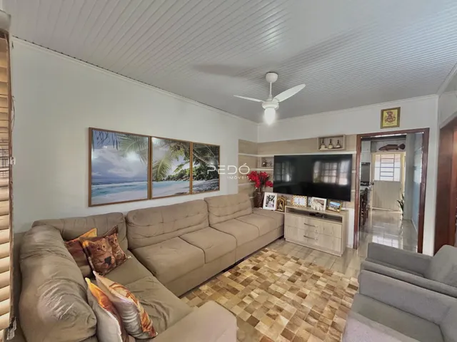 Sala de estar com sofá e piso de ladrilhos em uma residência.
