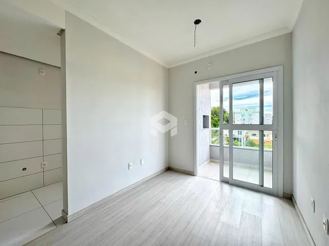 Sala de estar com piso de madeira clara e porta de vidro.