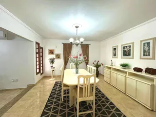 Sala de jantar com mesa e cadeiras em ambiente claro.