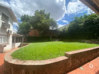 Jardim gramado cercado por um muro de tijolos.