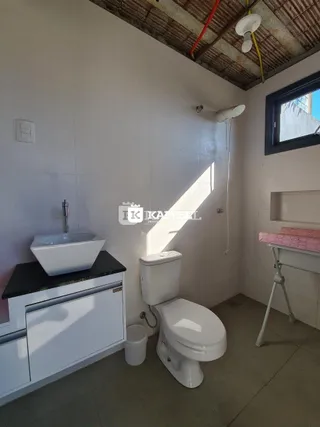 Foto de um banheiro com pia e vaso sanitário branco.