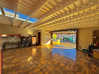 Foto de uma ampla sala com piso de cerâmica e abertura para o exterior.