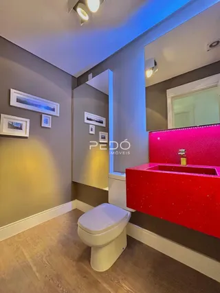 Foto de um banheiro interno com piso de madeira e louças brancas.