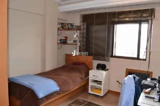 Quarto com cama de madeira e janela.