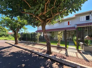 Vista externa de uma propriedade com cerca e vegetação.