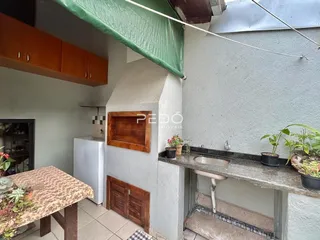 Vista de uma área externa com bancada e revestimento de parede em uma residência.