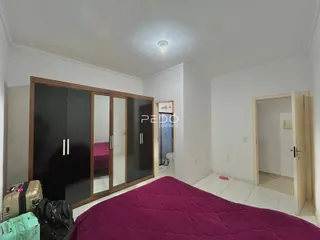 Quarto com cama e armário de madeira em um imóvel no Brasil.