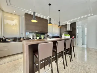 Vista da cozinha moderna com ilha e banquetas em Lajeado.