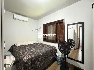 Quarto com cama coberta e ar condicionado instalado na parede.