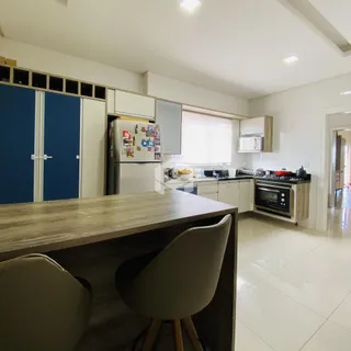 Foto de uma cozinha moderna com armários brancos e piso claro.