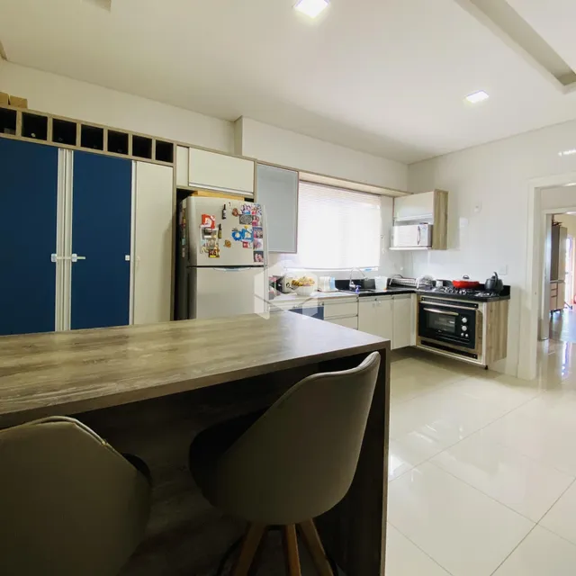 Foto de uma cozinha moderna com armários brancos e piso claro.