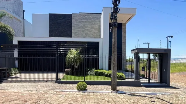 Fachada de uma residência moderna com portão e paisagismo em Lajeado, Brasil.