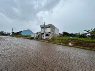 Vista externa de uma residência em Lajeado, Brasil, ao lado de uma estrada de paralelepípedos.