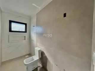 Foto de um banheiro com paredes brancas e piso claro.
