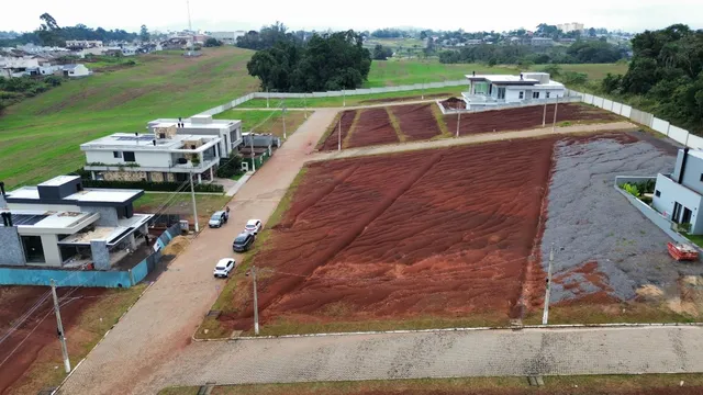 Vista aérea de um terreno em Lajeado, Brasil, mostrando áreas verdes e construções adjacentes.