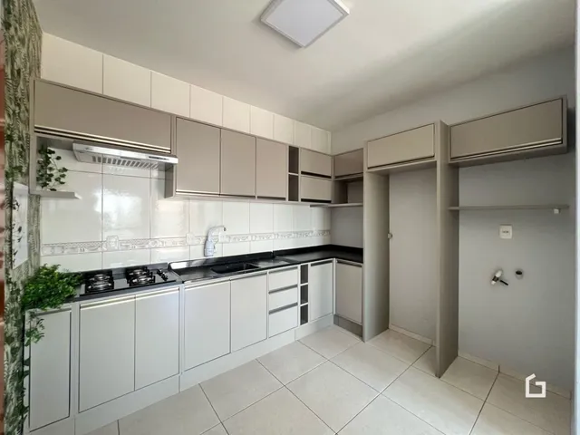 Foto de uma cozinha com armários brancos e piso claro.
