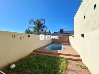 Foto de uma área externa com piscina e deck de madeira em um imóvel.