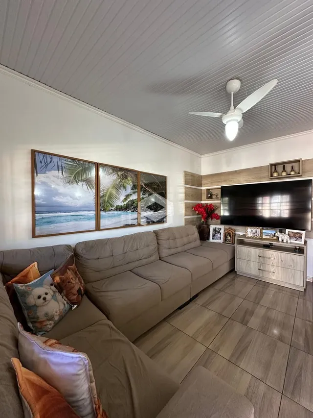 Sala de estar com sofá e painel de madeira na residência.