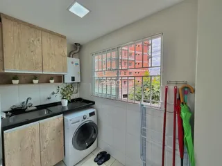 Cozinha com armários de madeira e janela de vista para o exterior.