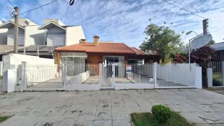 Fachada de uma residência em Lajeado, Brasil, com muro e portão branco.