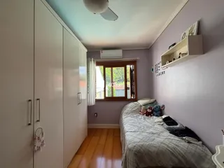 Quarto com armários e piso de madeira em Lajeado.