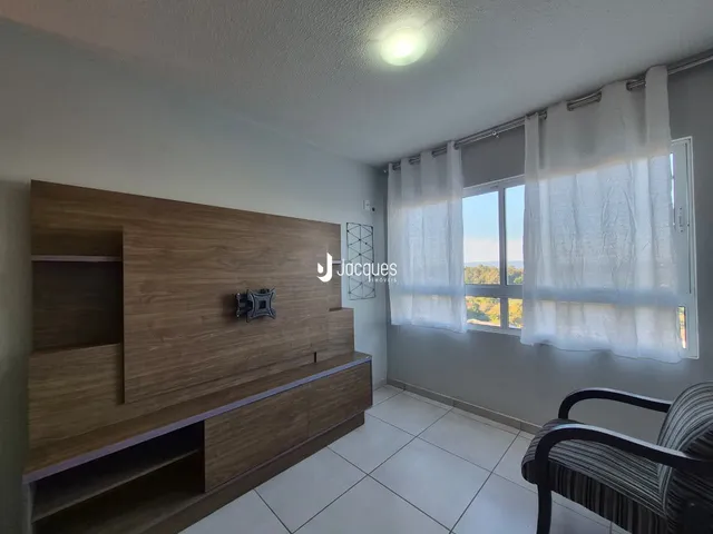 Quarto com painel de madeira e janela com cortinas brancas.
