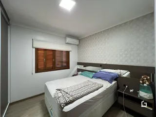 Quarto com duas camas e janela de madeira.