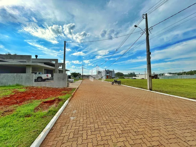 Vista externa de uma propriedade com uma estrada pavimentada e área gramada.
