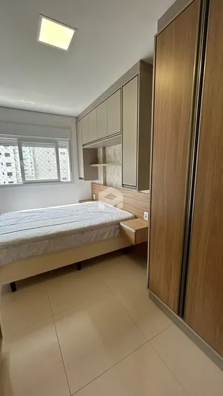 Quarto com armários e cama de madeira em um apartamento.