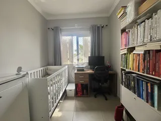 Quarto com móveis de madeira e estantes em um imóvel no Brasil.