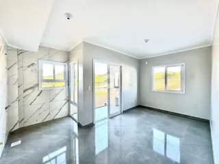 Interior de uma área com piso de mármore e paredes claras.