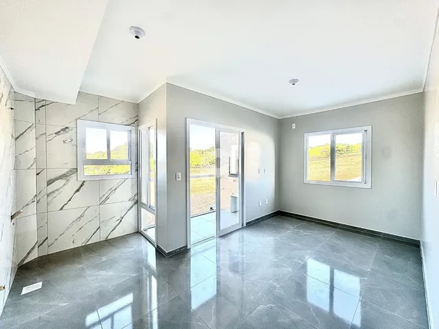 Interior de uma área com piso de mármore e paredes claras.