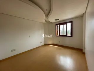 Interior de uma sala com piso de madeira e janela em um imóvel no Brasil.