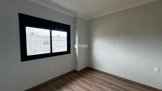 Ambiente interno com piso de madeira e janela de grande porte.