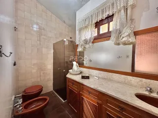 Foto de um banheiro com revestimento de cerâmica e armário de madeira.