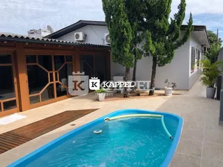 Foto da piscina externa com deck e área verde de uma residência em Lajeado.