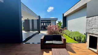 Fachada moderna de uma residência com deck de madeira e paisagismo.