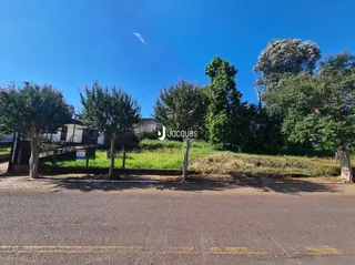 Vista externa de uma propriedade com vegetação e estrada no primeiro plano.