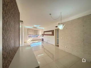 Interior de uma sala de estar ampla com piso de cerâmica e paredes claras.