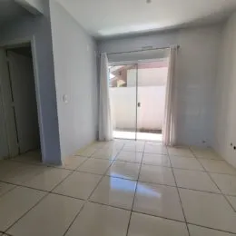 Corredor com piso de cerâmica e paredes brancas.