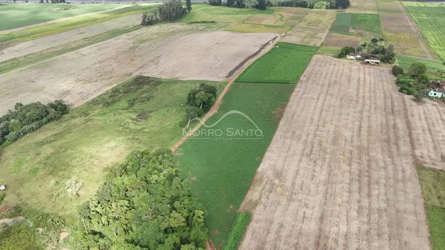 Vista aérea de uma propriedade rural com campos cultivados e vegetação em Lajeado.