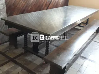 Uma mesa de madeira escura está posicionada em um ambiente interno.