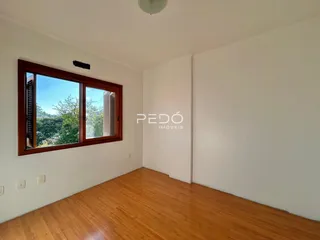 Sala de estar com piso de madeira e janela.