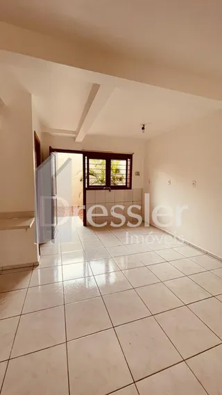 Vista de um corredor interno com piso de cerâmica clara.