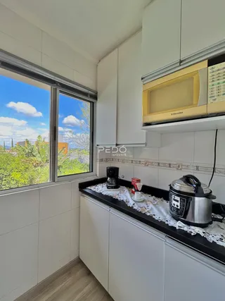 Vista da cozinha com janela para a paisagem verde.