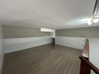 Foto de uma sala com piso de madeira e paredes brancas.