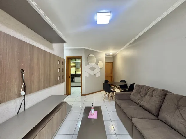 Sala de estar com sofá e mesa de jantar em um apartamento.