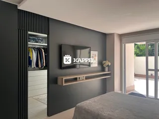 Um quarto moderno com cama e armário em um ambiente com acesso a uma varanda.