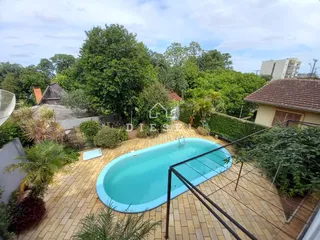 Vista de uma piscina e área externa com jardim em Lajeado.