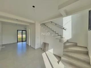 Ambiente interno de uma sala com escadaria em um imóvel.